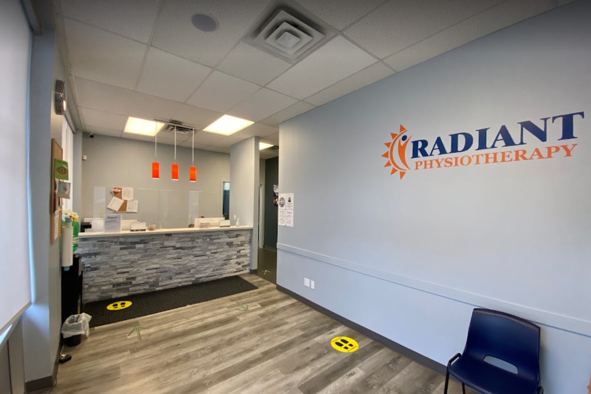 The reception desk and waiting area inside Radiant Physiotherapy, with the clinic's sign on the wall
